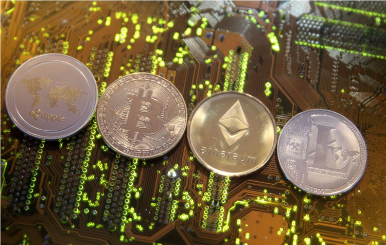 Representations of the Ripple, Bitcoin, Etherum and Litecoin virtual currencies are seen on motherboard in this illustration picture