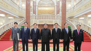 South Korean envoys pose for a photo with North Korean leader Kim Jong Un