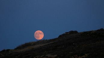 The rising full moon is seen from the Xwejni Salt Pans on the island of Gozo