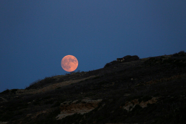 The rising full moon is seen from the Xwejni Salt Pans on the island of Gozo