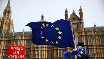 An anti-Brexit demonstrator waves flags