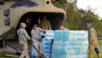 U.S. Army personnel unload food and water from a CH-47 Chinook helicopter