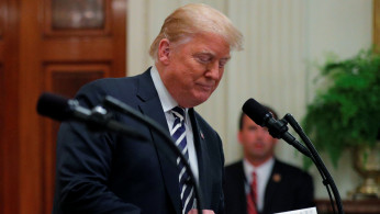 President Trump turns page of his statement during joint news conference at the White House