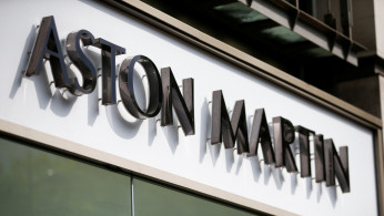 An Aston Martin logo is seen on the outside of a dealership in central London