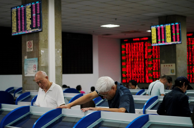 Investors look at computer screens showing stock information at a brokerage house in Shanghai