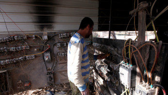 An electrician works at a local generator in Baghdad