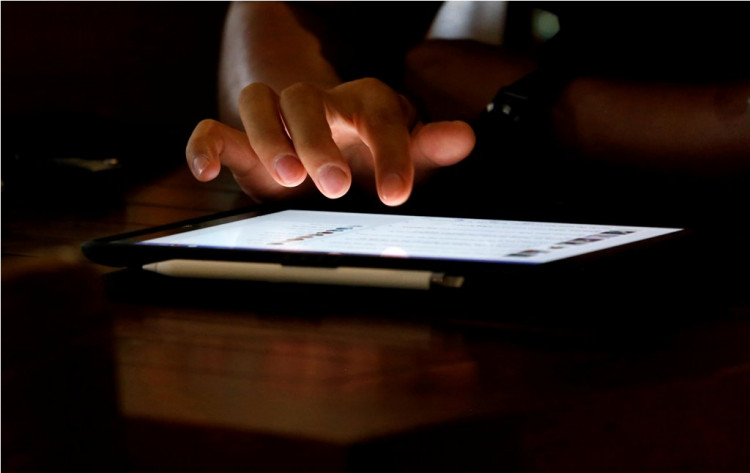 A man uses an iPad device in a coffee shop in Hanoi