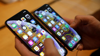 A customer compares the size of the new iPhone XS and iPhone XS Max at the Apple Store in Singapore