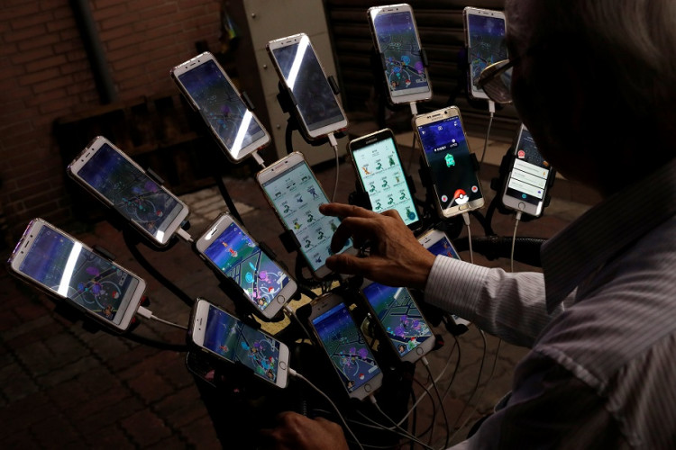 Taiwanese Chen San-yuan, known as "Pokemon grandpa", plays mobile game "Pokemon Go" by Nintendo, near his home with 15 mobile phones, in New Taipei City