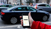 An UBER application is shown as cars drive by in Washington, DC.