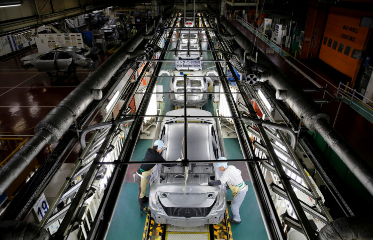 Employees work on an assembly line of the Toyota Motor Corp's Prius hybrid car at the Tsutsumi plant in Toyota