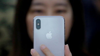 An attendee uses a new iPhone X during a presentation for the media in Beijing
