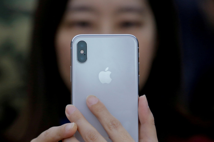 An attendee uses a new iPhone X during a presentation for the media in Beijing
