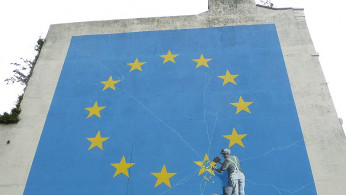 Banksy Brexit mural of man chipping away at EU flag 