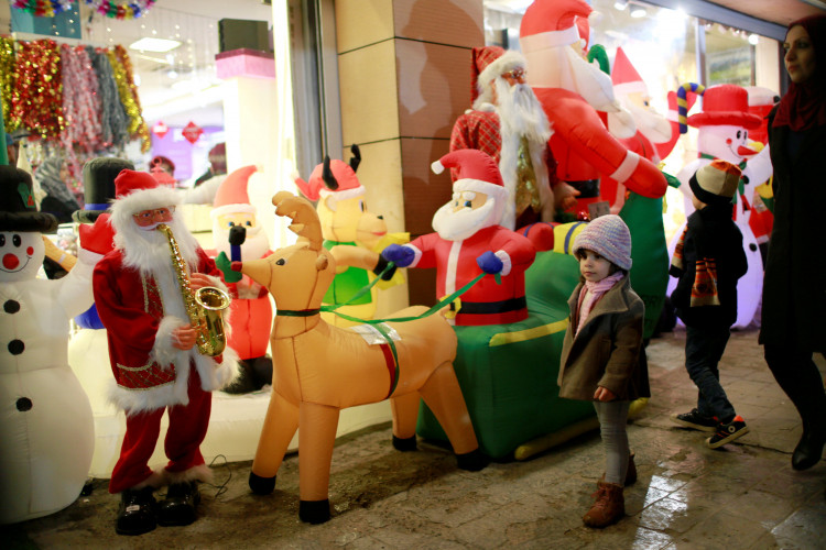 Iraqi children walk next to a store selling Christmas decorations in Baghdad