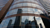 Nearby buildings are reflected on the exterior of a commercial tower at the financial Central district in Hong Kong