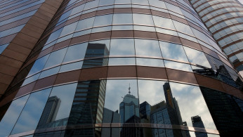 Nearby buildings are reflected on the exterior of a commercial tower at the financial Central district in Hong Kong