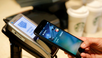 Man uses iPhone 7 smartphone to demonstrate mobile payment service Apple Pay at cafe in Moscow
