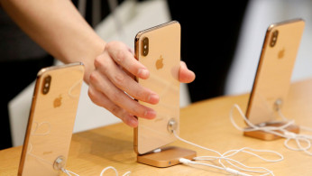 People look at iPhones at the World Trade Center Apple Store during a Black Friday sales event in Manhattan, New York City