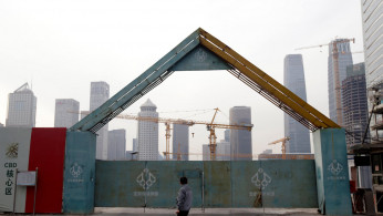 A man walks outside the construction sites in Beijing's central business area
