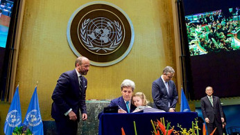 Secretary Kerry Holds Granddaughter Dobbs-Higginson on Lap While Signing COP21 Climate Change Agreement