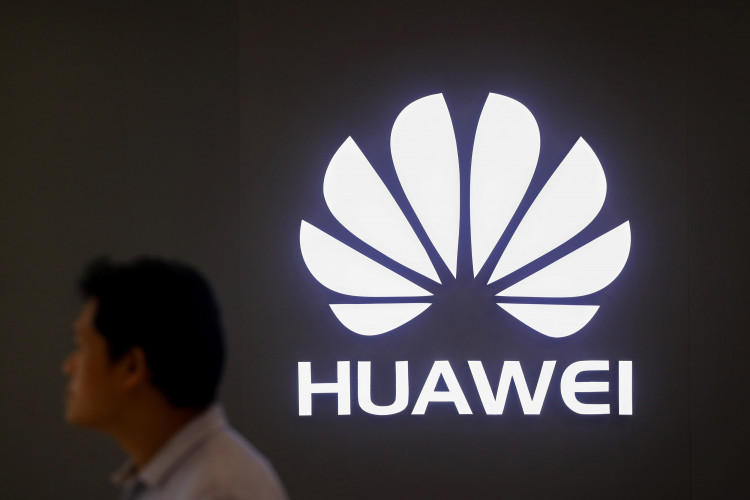 A man walks past a Huawei's company logo outside its shop in Bangkok
