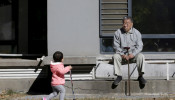 An 80-year-old man, surnamed Li, watches as a girl plays at a residential community in Beijing, China, October 30, 2015. 