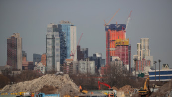 Cranes are seen among construction equipment in the Brooklyn borough of New York City