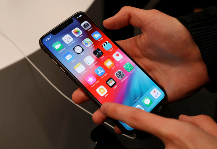 FILE PHOTO: A customer tests a smartphone during the launch of the new iPhone XS and XS Max sales at a shop in Moscow, Russia