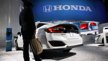 A show attendee looks over a Honda Clarity plug-in hybrid at the North American International Auto Show in Detroit, Michigan