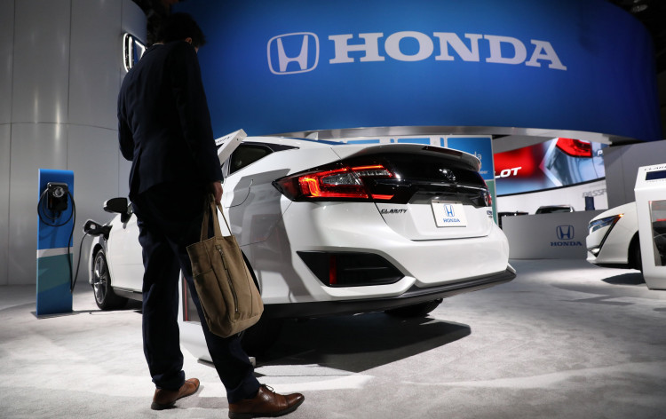 A show attendee looks over a Honda Clarity plug-in hybrid at the North American International Auto Show in Detroit, Michigan