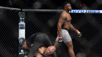 Francis Ngannou (red gloves) walks away after finishing Cain Velasquez (blue gloves) 