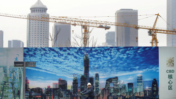 A man cycles outside construction sites in Beijing
