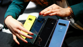 A Samsung employee arranges the new Samsung Galaxy S10e, S10, S10+ and the Samsung Galaxy S10 5G smartphones at a press event in London