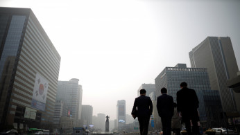 Businessmen walk during a polluted day in Seoul