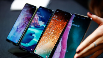 A Samsung employee arranges the new Samsung Galaxy S10e, S10, S10+ and the Samsung Galaxy S10 5G smartphones at a press event in London