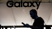 A visitor uses a mobile phone at the Samsung booth at the Mobile World Congress in Barcelona