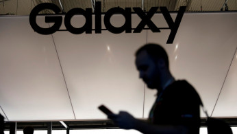 A visitor uses a mobile phone at the Samsung booth at the Mobile World Congress in Barcelona