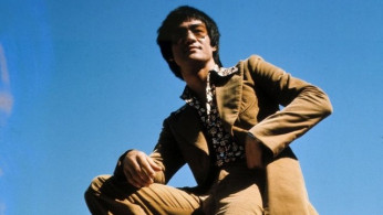 Bruce Lee looking fly on his red Mercedes-Benz 450SL in the 1970s.
