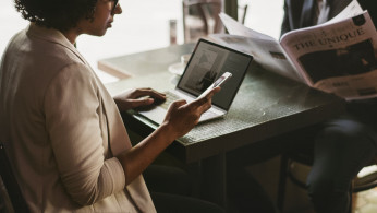 woman in suit using smartphone and laptop