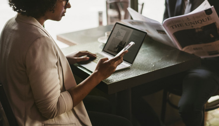 woman in suit using smartphone and laptop