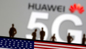 Small toy figures are seen in front of a displayed Huawei and 5G network logo in this illustration picture