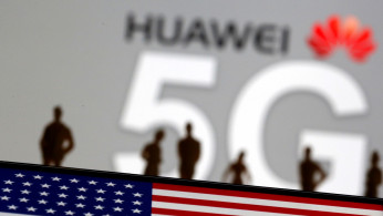 Small toy figures are seen in front of a displayed Huawei and 5G network logo in this illustration picture
