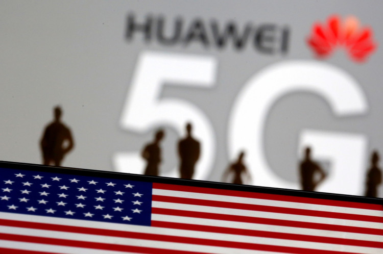 Small toy figures are seen in front of a displayed Huawei and 5G network logo in this illustration picture