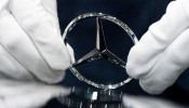 An employee wipes the logo on a car at the Mercedes Benz automobile assembly plant outside Moscow