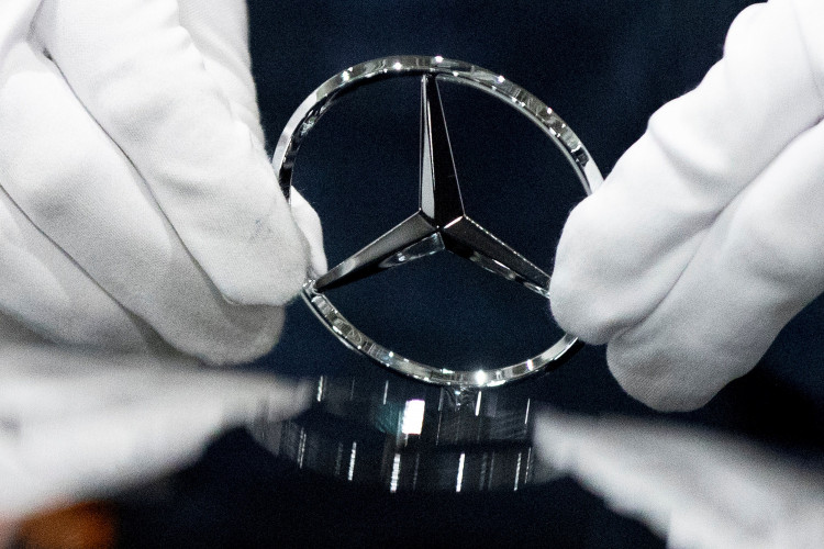 An employee wipes the logo on a car at the Mercedes Benz automobile assembly plant outside Moscow