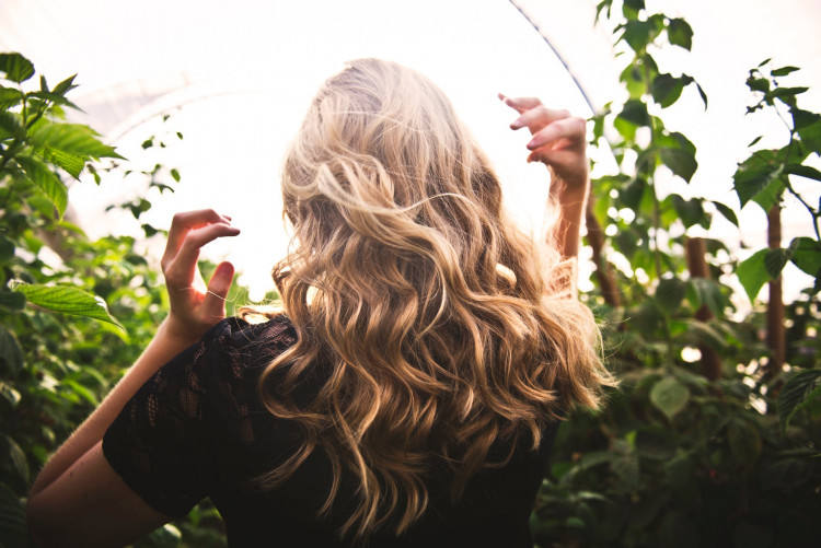 Blond Haired Woman Standing Between Green Plants