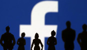 Small toy figures are seen in front of Facebook logo in this illustration picture