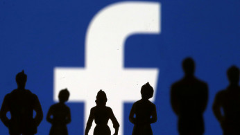 Small toy figures are seen in front of Facebook logo in this illustration picture