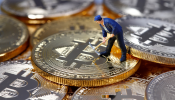 A small toy figure is seen on representations of the Bitcoin virtual currency in this illustration picture